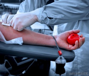 person-in-gown-taking-blood-from-patients-arm-holding-red-ball